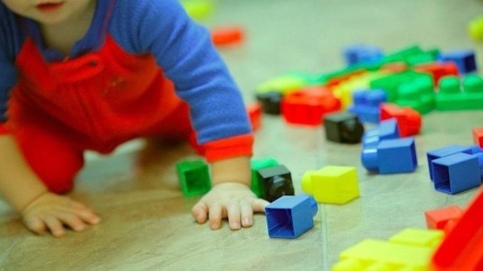 Imagen de un bebé jugando con unas piezas en una guardería ARCHIVO