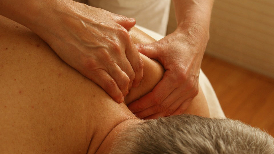 Imagen de un masajista practicando un masaje a un hombre en una camilla ARCHIVO