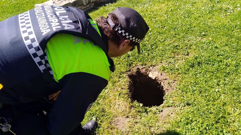 Un agente de la Policía Muncipal inspecciona el socavón producido junto al Club de Remo de Pamplona en el que ha quedado atrapado un hombre de 60 años CEDIDA