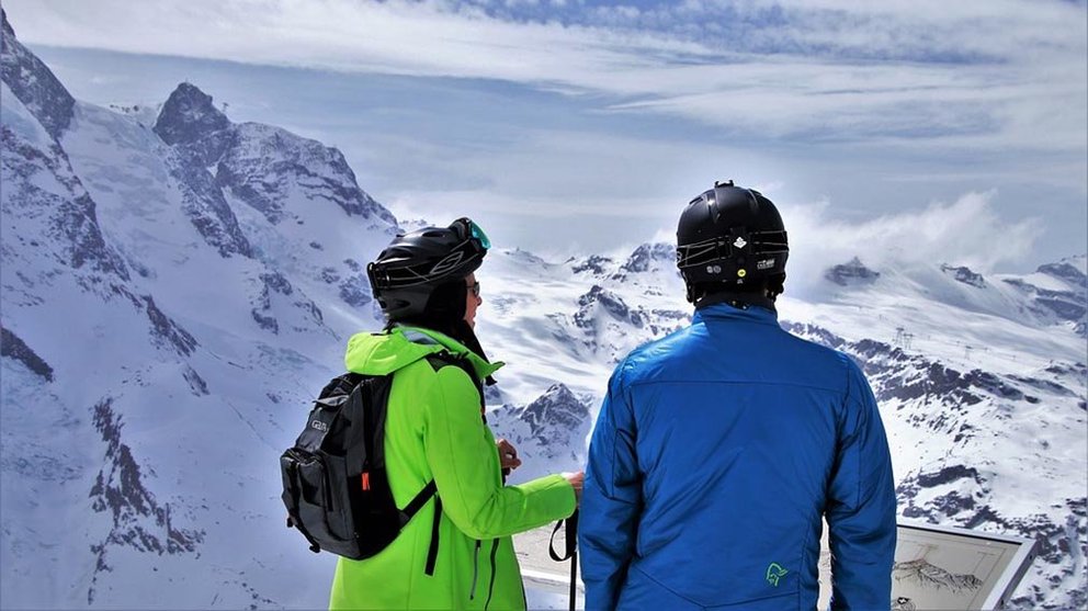 Imagen de recurso de dos montañeros frente a los Alpes suizos