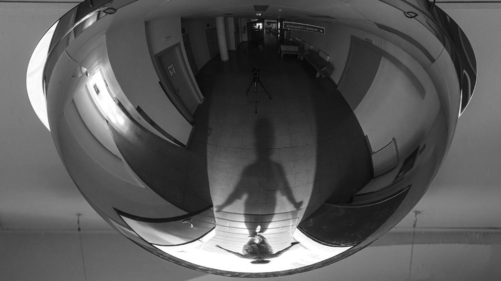 El reflejo de una enfermera accediendo a un pasillo en el Complejo Hospitalario de Navarra durante el turno de noche. MARISOL ELÍA