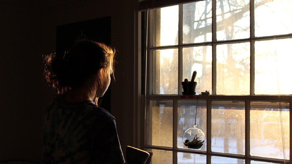 Una joven mirando por la ventana. ARCHIVO