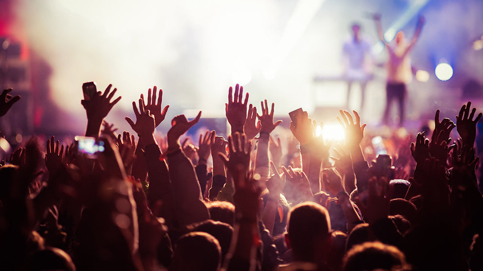 Cientos de asistentes a un concierto animan con las manos al aire al grupo que toca sobre el escenario ARCHIVO