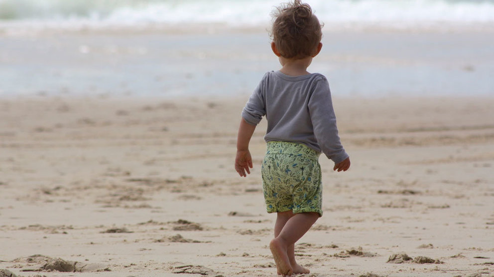Un bebé pasea por la playa. ARCHIVO