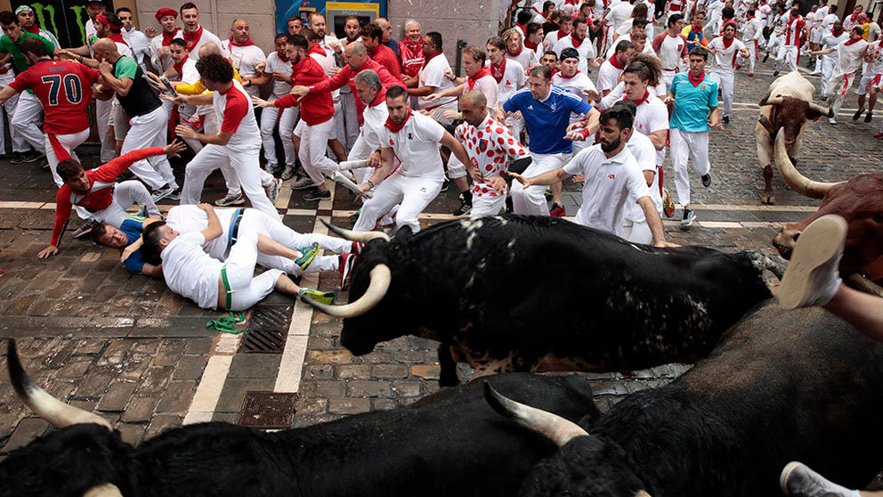 070718-4. Pamplona (Spain), 07/07/2018.- Fighting bulls from the ranch of Puerto de San Lorenzo stampede around a corner in the first 'encierro' or running-with-the-bulls during the Festival of San Fermin 2018 in Pamplona, Spain, 07 July 2018. The festival, locally known as Sanfermines, is held annually from 06 to 14 July in commemoration of the city's patron saint. Hundreds of thousands of visitors from all over the world attend the fiesta. Many of them physically participate in the highlight event - the running of the bulls, or encierro - where they attempt to outrun the bulls along a route through the narrow streets of the old city. (España, Estados Unidos) EFE/EPA/JIM HOLLANDER