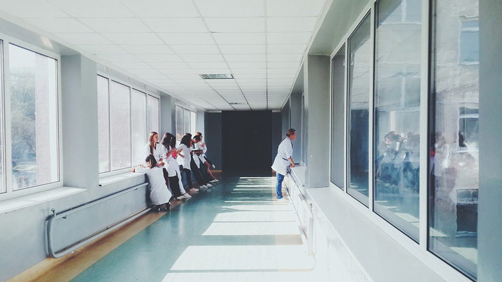 Varios médicos y enfermeras esperan en el pasillo de un hospital junto a unos pacientes ARCHIVO