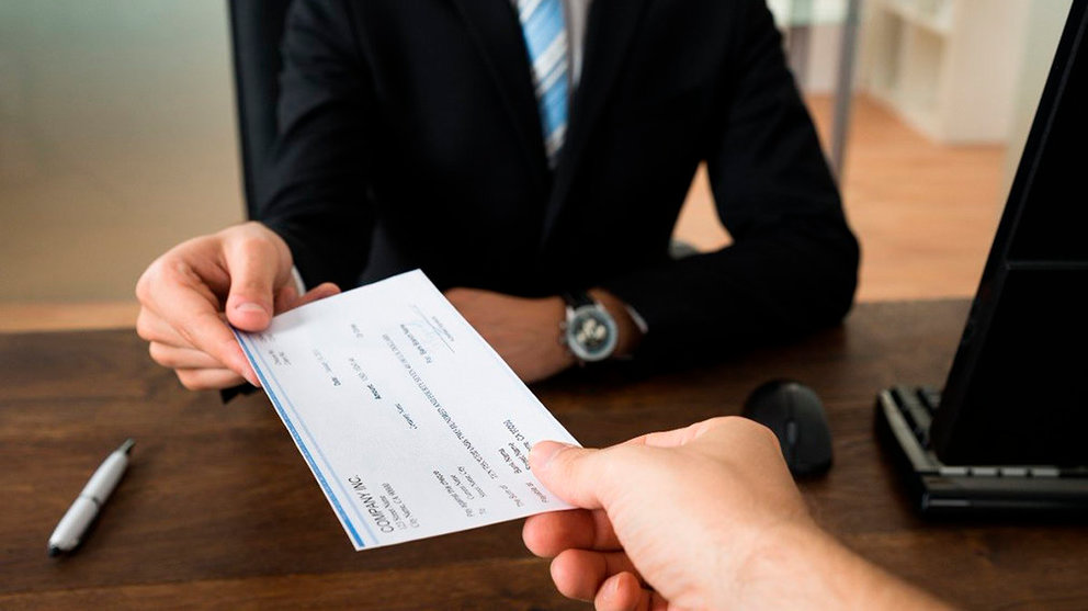 El trabajador de un banco firma un préstamo hipotecario con un cliente en el despacho de una entidad financiera ARCHIVO