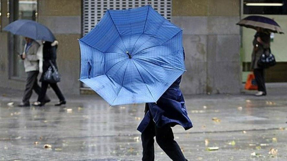 Una persona sujeta un paraguas en su lucha contra el viento. ARCHIVO