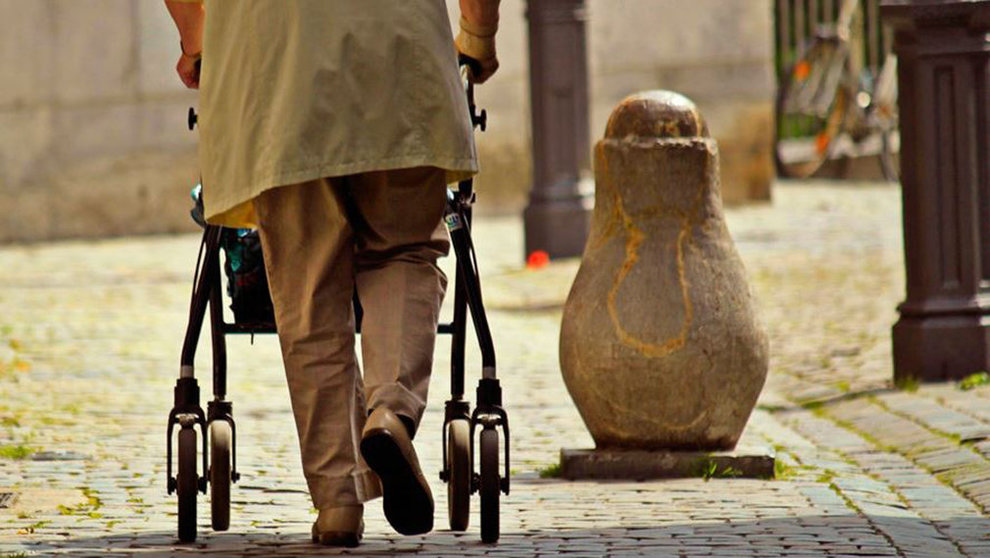 Una persona mayor pasea por una calle con un andador. ARCHIVO