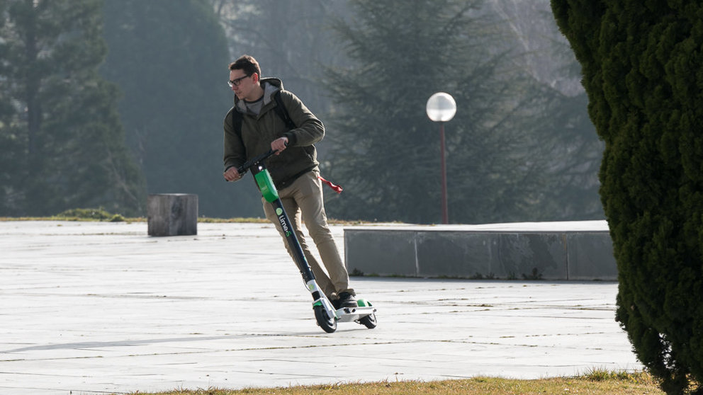 Un joven utiliza un patinete eléctrico de alquiler en el campus de la Universidad de Navarra (03). IÑIGO ALZUGARAY