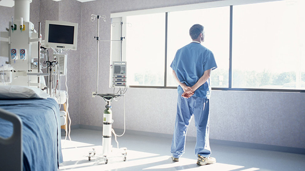 Imagen de un médico observando por la ventana de la habitación de un hospital ARCHIVO