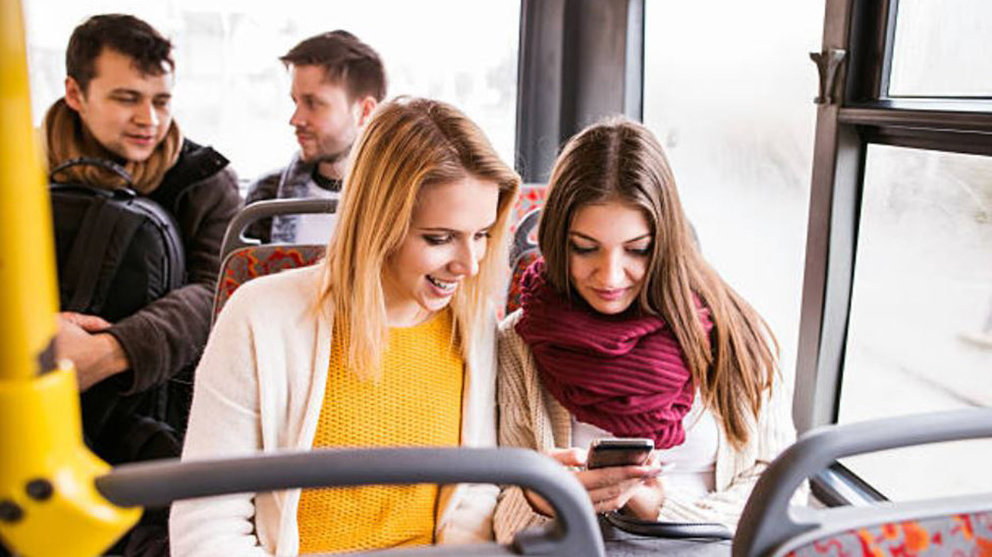 Imagen de un autobús escolar llevando a varios adolescentes que viajan usando su teléfono móvil a un instituto ARCHIVO