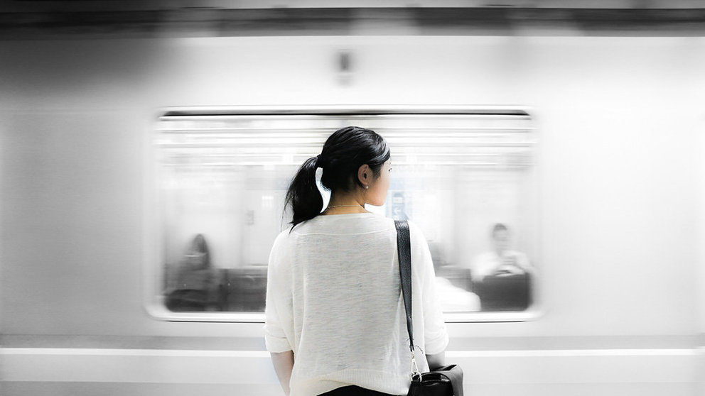 Una mujer aguarda a su tren en una estación.