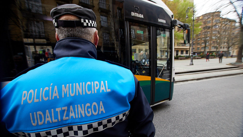 Un policía municipal supervisa dentro de la organización del transporte urbano la salida de una villavesa en el Paseo Sarasate de Pamplona. IÑIGO ALZUGARAY