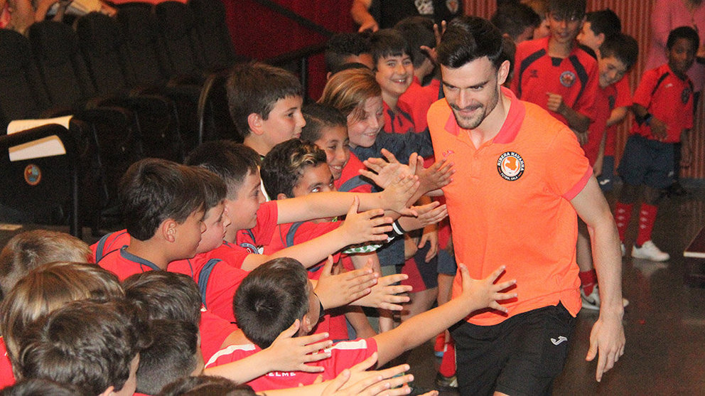 El jugador del Ribera Navarra Ferrán Plana recibe el saludo de los chavales de Ribaforada. Cedida.