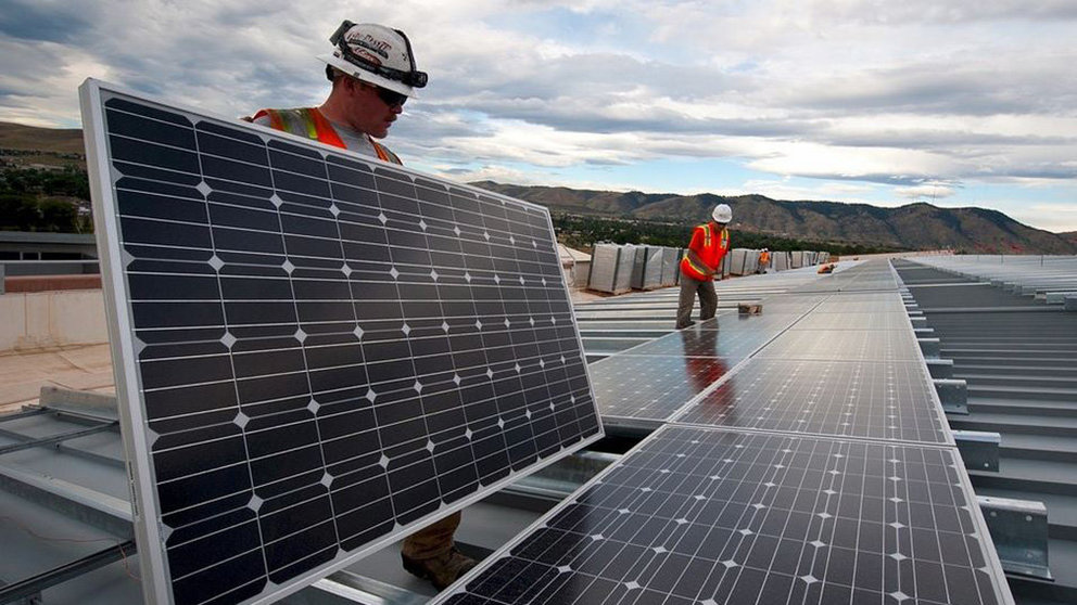 Varios operarios instalan placas solares sobre un edificio. ARCHIVO