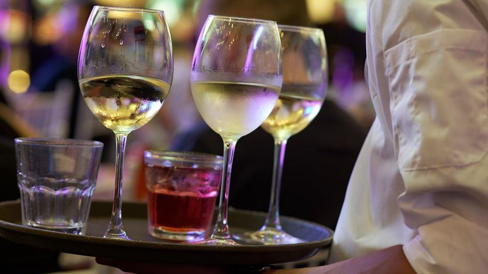 Un camarero lleva varias copas en una bandeja ARCHIVO