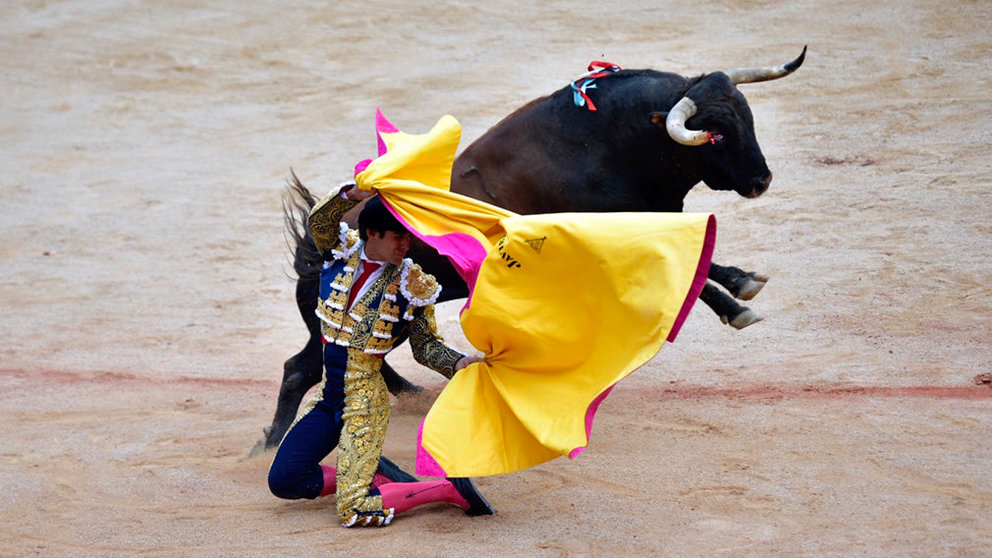 Javier Marín recibe de rodillas a su primer toro de la ganadería La Palmosilla, que ha sido retirado al haberse roto el cuerno. PABLO LASAOSA (2)