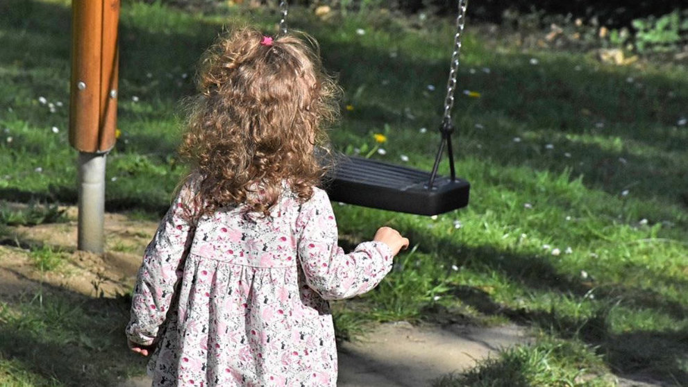 Una niña pequeña juega con un columpio en un parque ARCHIVO
