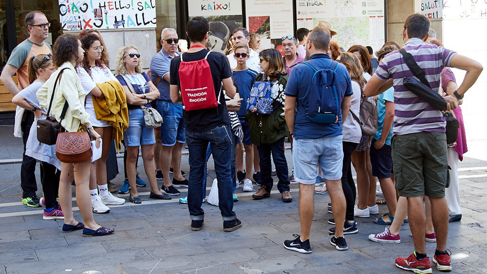 Varios turistas atienden las explicaciones de un guía en el casco viejo de Pamplona. IÑIGO ALZUGARAY