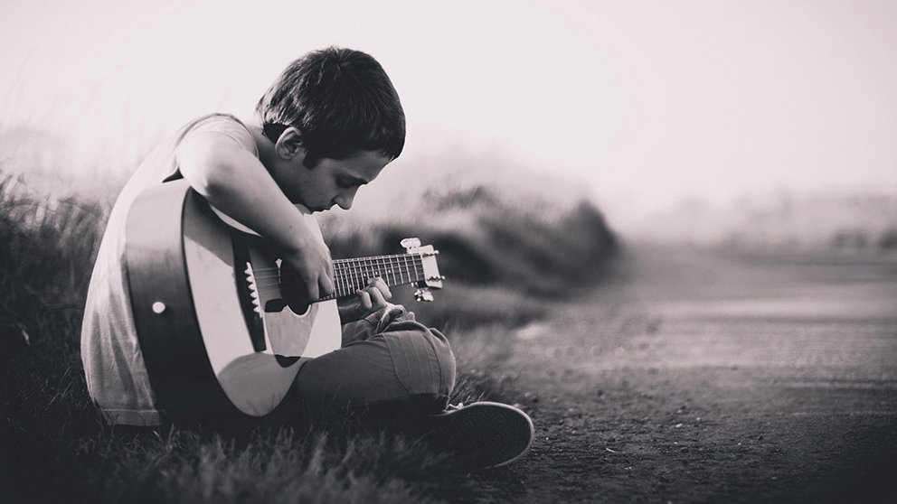 Imagen de un niño tocando una guitarra con una mala postura. ARCHIVO