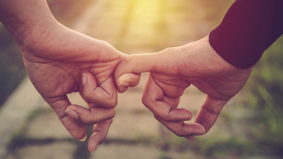 Dos personas enamoradas se agarran de la mano.