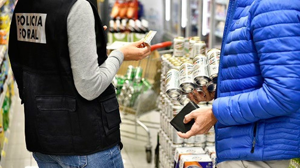 Un agente controla que se dispense alcohol a mayores de 18 años en un supermercado. POLICÍA FORAL