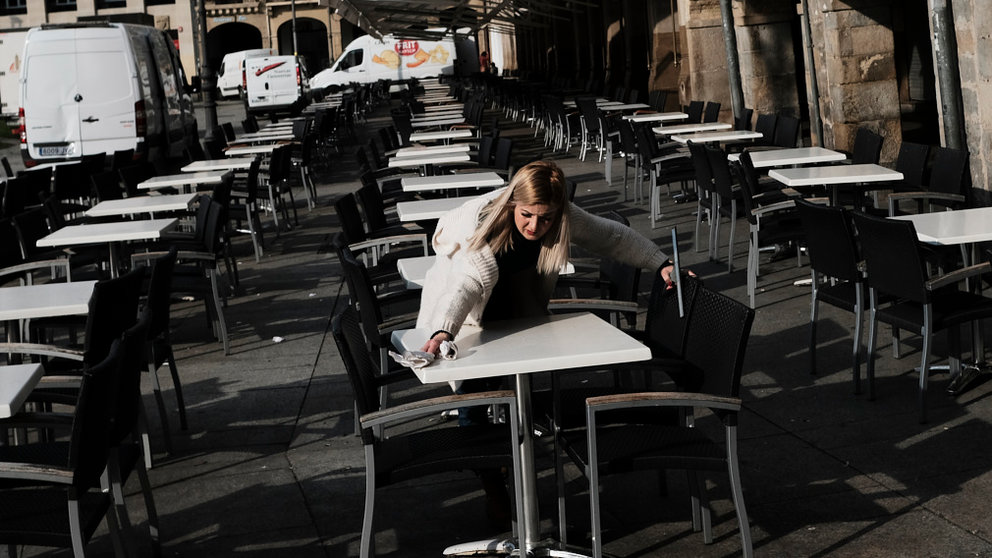 Una camarera limpia la terraza de un establecimiento en la Plaza del Castillo. PABLO LASAOSA