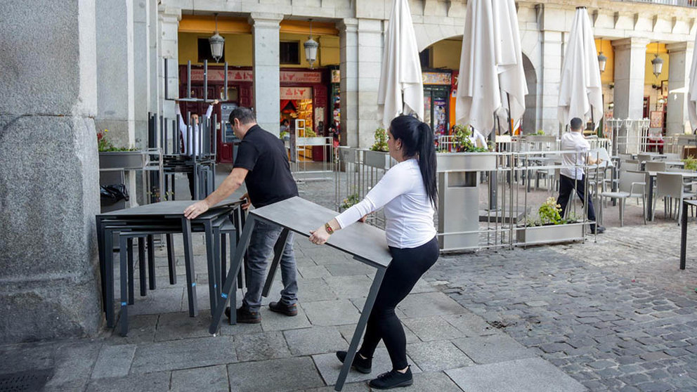 Varios empleados de un bar de la Plaza Mayor de Madrid recogen la terraza un día antes de que se cierre toda la hostelería para frenar contagios por coronavirus, en Madrid (España) a 13 de marzo de 2020. - Ricardo Rubio - Europa Press