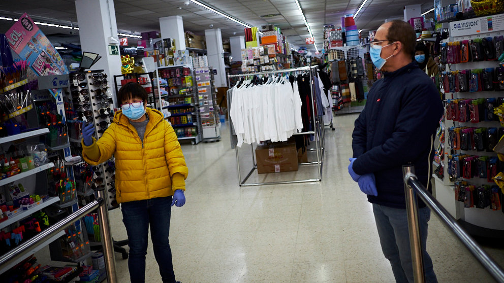 Dos personas encargadas de una tienda de todoa cien con mascarillas y guantes en prevención del coronavirus. PABLO LASAOSA