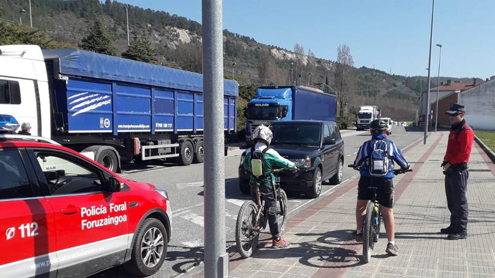 Un policía informa a dos ciclistas de la prohibición de salir de sus casas para ir a andar en bici por el coronavirus POLICÍA FORAL
