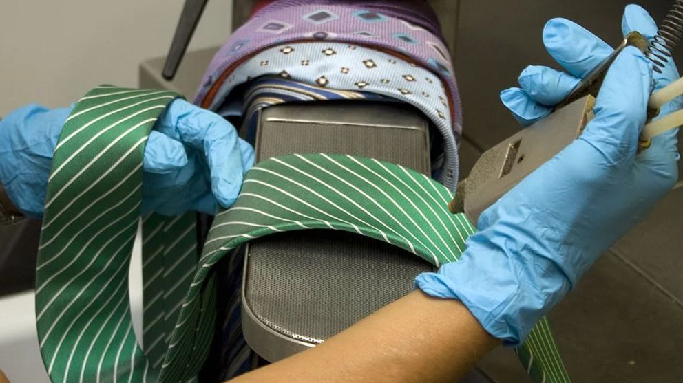 Una persona limpia unas corbatas en una tintorería ARCHIVO