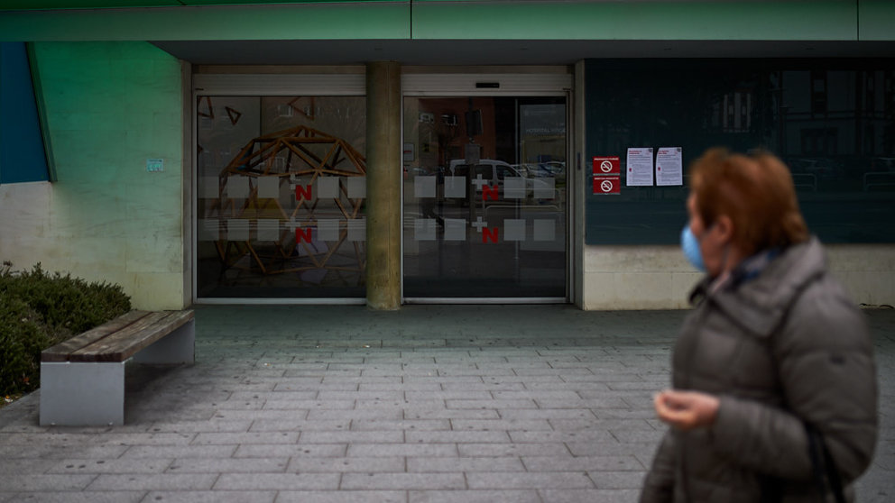 Una mujer con una mascarilla pasa por delante de la puerta del Hospital de Navarra durante la crisis del coronavirus. MIGUEL OSÉS