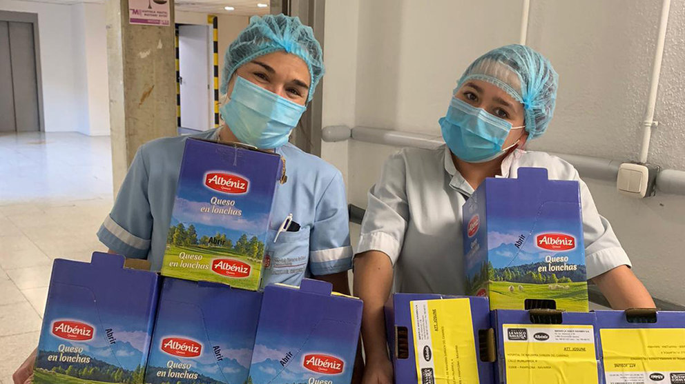 Dos enfermeras recogen las cajas de queso que les han regalado. Cedida.