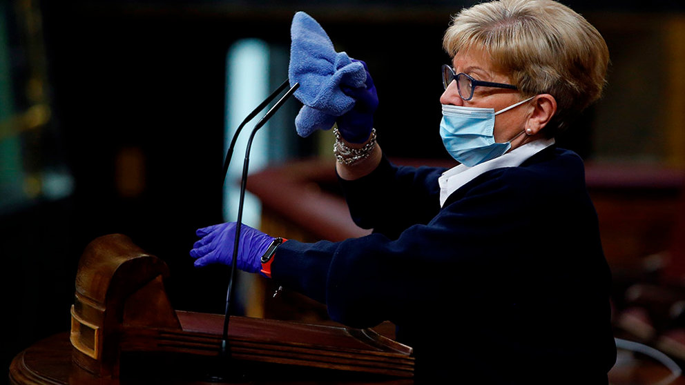 Lower Chamber's cleaner Conchi Garcia disinfects the platform after the speech of each MP during the plenary session at Lower Chamber of Spanish Parliament, in Madrid, Spain, 09 April 2020. The session is to be focused in passing a new extension of the state of alarm due to coronavirus outbreak. EFE/Mariscal POOL
