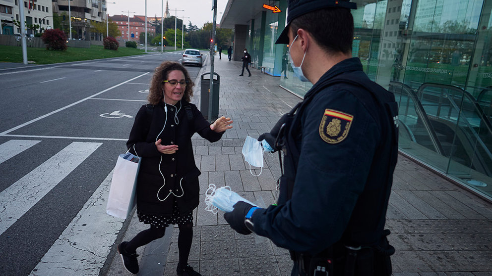 Un policía nacional entrega una mascarilla a una mujer en una calle de Pamplona el día en el que se reactiva la actividad laboral no esencial en Navarra en las empresas cuyos empleados no puedan teletrabajar cuando se cumple un mes desde el inicio del estado de alarma decretado a consecuencia del coronavirus, en Pamplona (Navarra, España), a 14 de abril de 2020.

14 ABRIL 2020;PAMPLONA;NAVARRA;POLICIAS;ENTREGA MASCARILLAS;CORONAVIRUS;VIRUS;COVID-19

14/4/2020