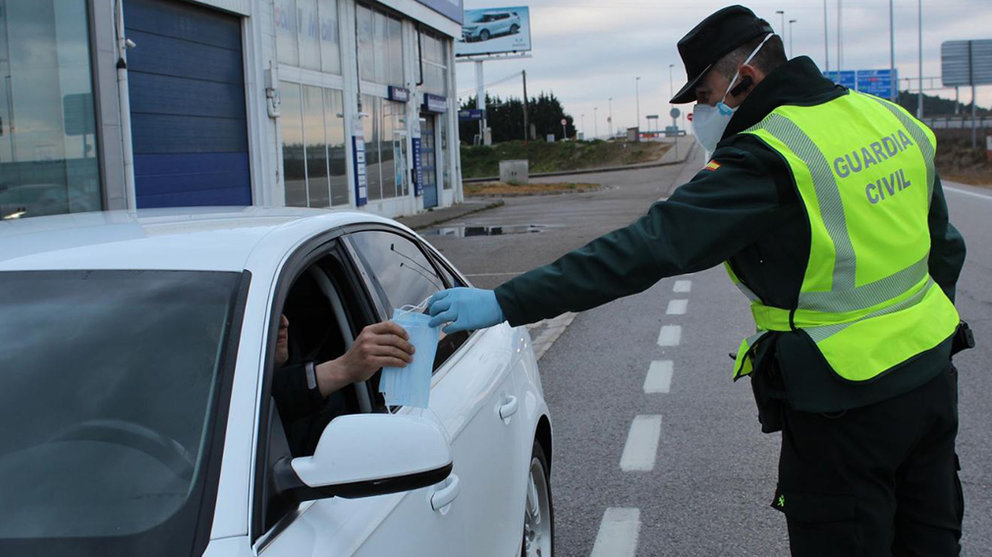 Un guardia civil entrega una mascarilla a un conductor durante la crisis del coronavirus GUARDIA CIVIL