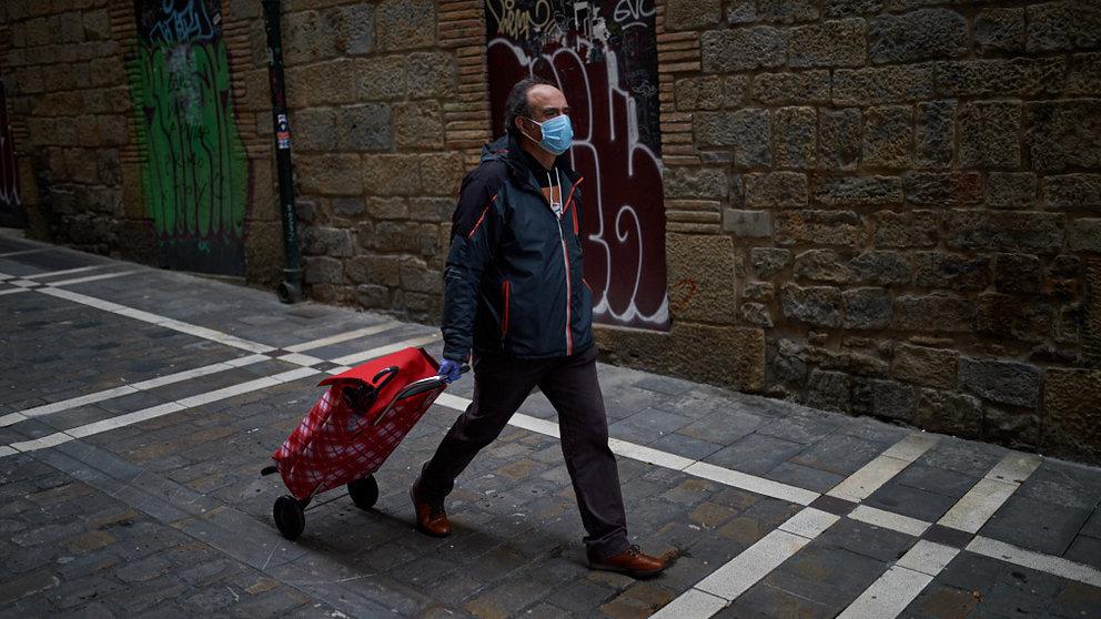 Un.hombre con mascarilla y carro de la compra recorre las calles del centro de Pamplona durante la crisis por coronavirus en Pamplona. Miguel Osés