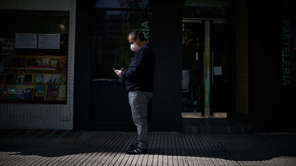 Un hombre con mascarilla espera para hacer la compra durante la crisis por coronavirus en Pamplona. Miguel Osés