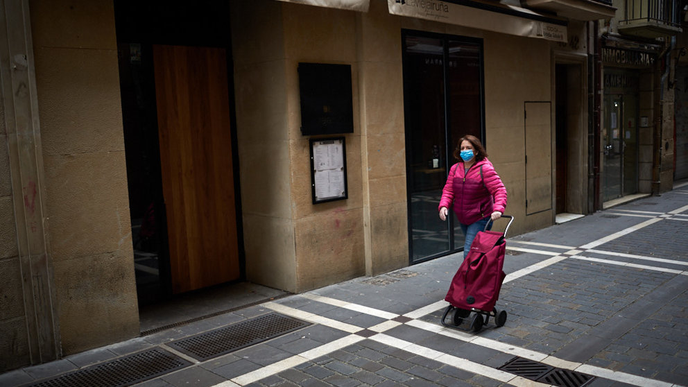 Una mujer camina por el casco viejo con una mascarilla y un carro de la compra durante la crisis del coronavirus en Pamplona. Miguel Osés