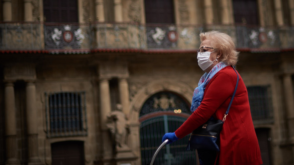 Una mujer con mascarilla camina por delante del Ayuntamiento durante la crisis del coronavirus en Pamplona. Miguel Osés