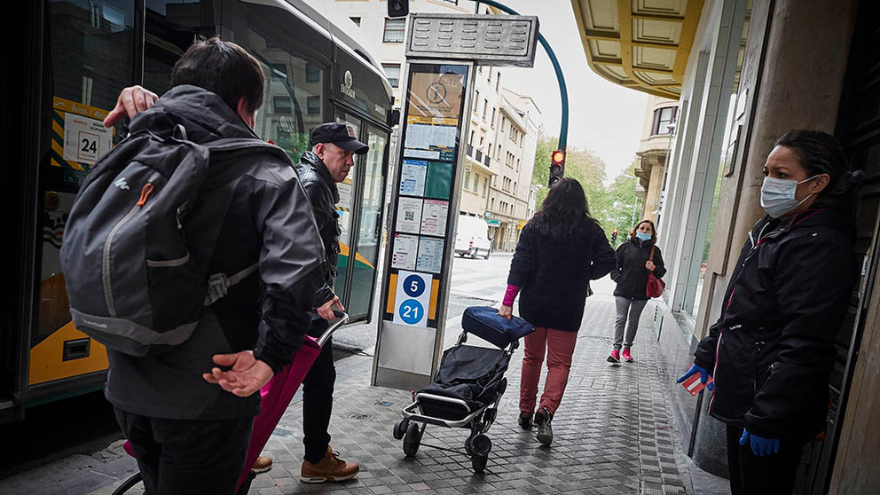 Varios pasajeros bajan de un autobús mientras una mujer con mascarilla los observa en el día 47 del estado de alarma, en Pamplona / Navarra (España), a 30 de abril de 2020.

30 ABRIL 2020 CORONAVIRUS;COVID-19;ESTADO DE ALARMA;PANDEMIA;

30/4/2020