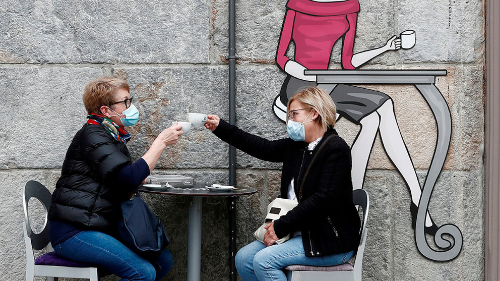 Dos personas brindan con un café en una terraza de Pamplona. EFE/ Jesús Diges