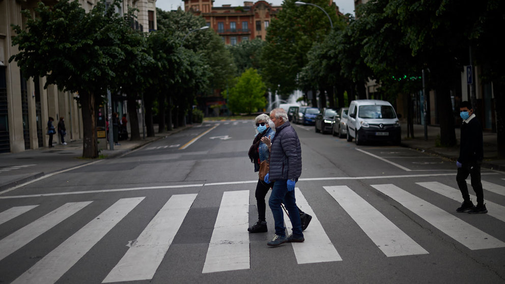 Varias personas con mascarillas cruzan el paso de cebra durante la crisis del coronavirus en Pamplona. Miguel Osés