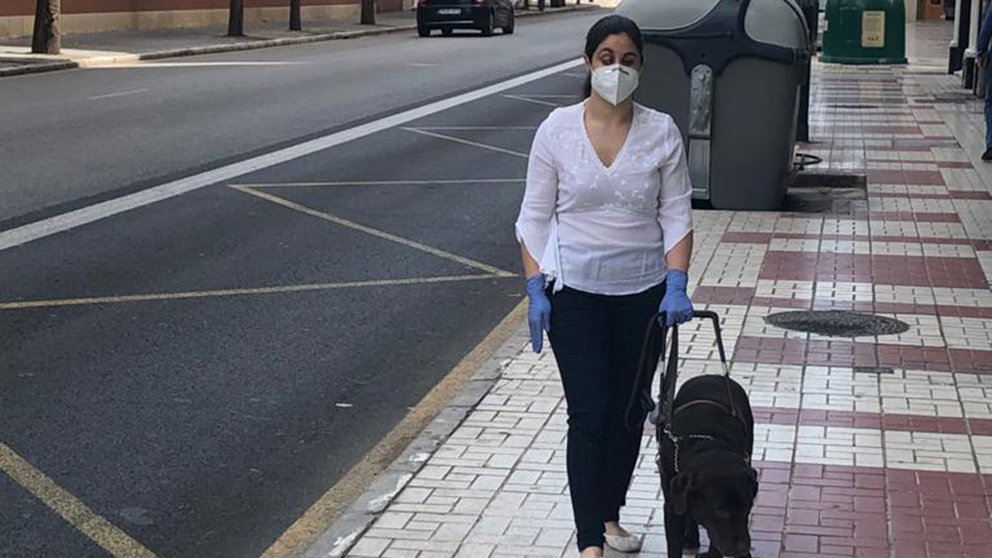 Una persona ciega se apoya en un perro para caminar por la calle. Cedida.