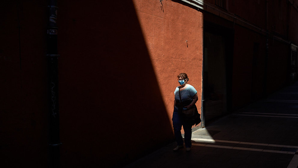 Una mujer con mascarilla pasea por las calles del casco viejo durante la crisis del coronavirus en Pamplona. MIGUEL OSÉS
