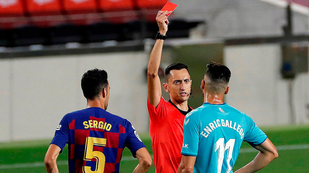El árbitro Sánchez Martínez (c) enseña la tarjeta roja a delantero de Osasuna Enric Gallego (d), durante el partido correspondiente a la jornada 37 de primera división disputado esta noche en el estadio del Camp Nou, en Barcelona. EFE/Alberto Estévez