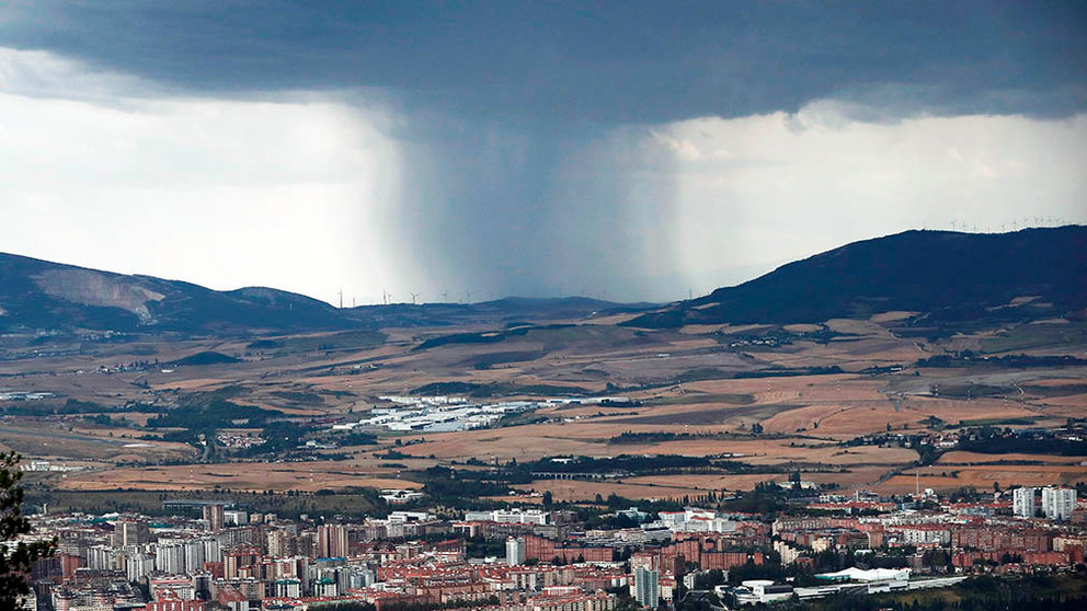 GRAFCAV7984. PAMPLONA, 12/08/2020.-  Dos ciclistas descienden con sus bicicletas del Monte de San Cristobal desde donde se puede apreciar la tormenta que en esos momentos caía en la zona de la localidad de Monreal en una jornada donde diez comunidades, con Galicia, Asturias y Cataluña en nivel naranja y Navarra en amarillo, mantienen alertas por tormentas y lluvias, la mayoría en la franja norte, que pueden acumular 40 litros por metro cuadrado en una hora, con granizo y rachas muy fuertes, y tres regiones cantábricas tienen avisos por fuerte oleaje. EFE/ Jesús Diges
