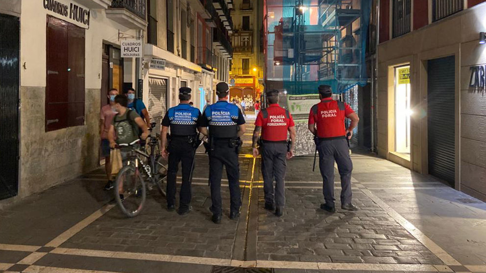 Agentes de la Policía Municipal de Pamplona y de la Policía Foral patrullan juntos por la capital navarra para frenar el coronavirus.  (1)