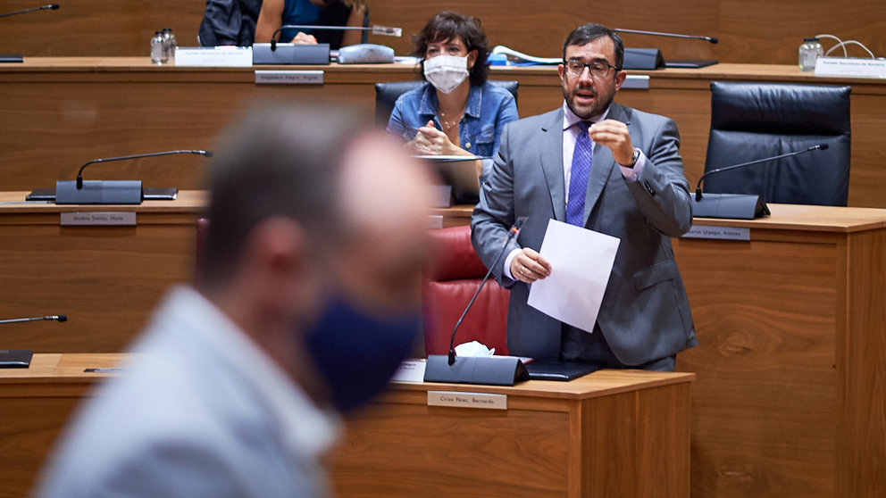 Javier Remirez, vicepresidente del gobierno habla durante el pleno parlamentario. En la imagen Javier Esparza cruza por delante del vicepresidente. MIGUEL OSÉS